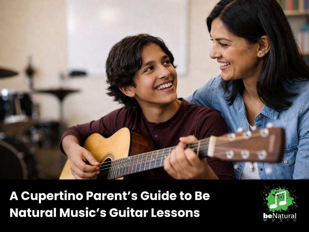A mother and son smile while he plays guitar in a music room, promoting Be Natural Music’s guitar lessons.